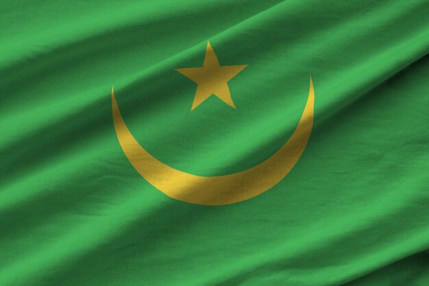 Mauritania flag with big folds waving close up under the studio light indoors The official symbols and colors in banner