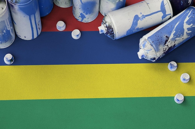 Mauritius flag and few used aerosol spray cans for graffiti\
painting street art culture concept