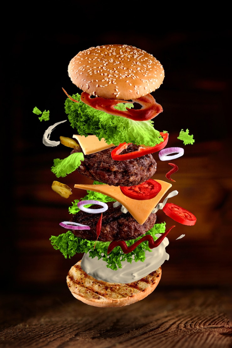 Foto maxi hamburger, dubbele cheeseburger met vliegende ingrediënten geïsoleerd op houten
