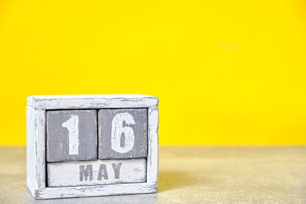 Photo may 16 calendar made wooden cubes yellow backgroundwith an empty space for your text