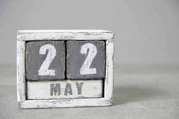Фото Календарь на 22 мая из деревянных кубиков на сером фоне с пустым местом для текста