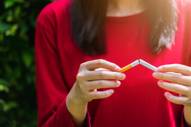 May 31 of World No Tobacco Day, Asian smoker woman use hands breaking down cigarettes, Stop or quit smoking concept