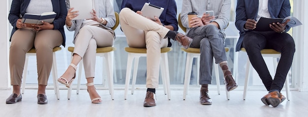 May as well kill some time while we wait. Cropped shot of an unrecognisable group of businesspeople sitting in the office and waiting.