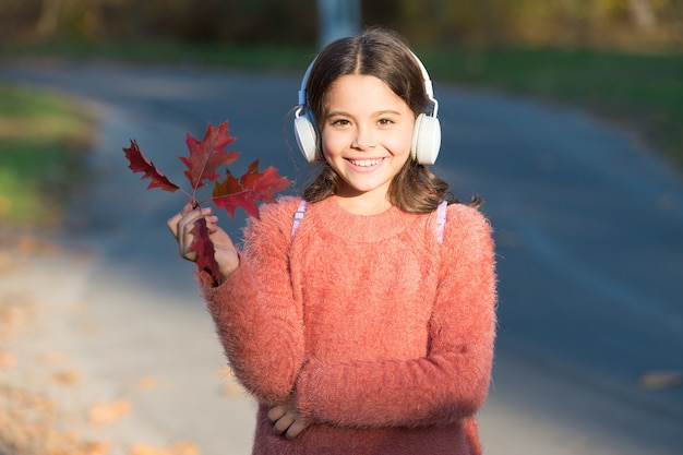 May this autumn be as melodious as happy song. Happy small girl listen to music on autumn landscape. Little child enjoy listening to happy melody. Happy hour starts here.
