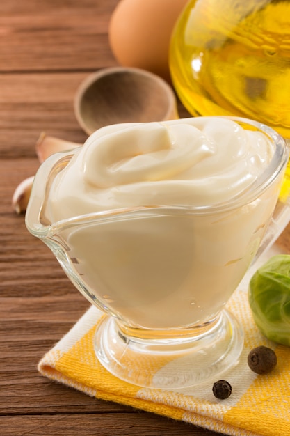 Mayonnaise sauce in bowl on wood