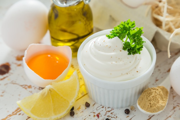 Mayonnaise sauce and ingredients on wood table