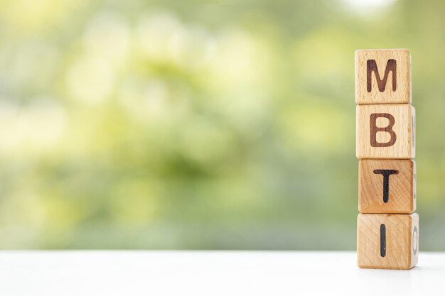 MBTI word is written on wooden cubes on a green summer background