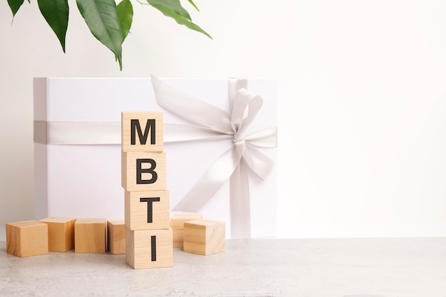 MBTI word made with building blocks on the table next to a flower and a gift box