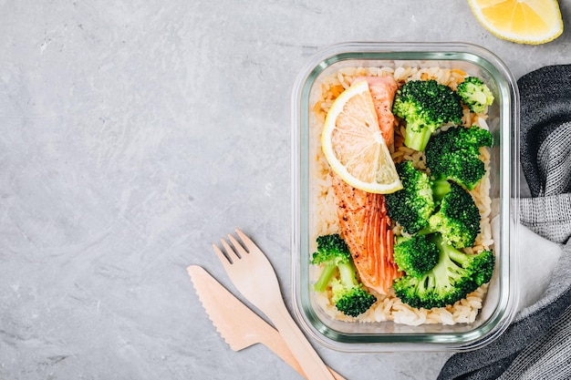 Meal prep lunch box containers with grilled salmon fish rice green broccoli