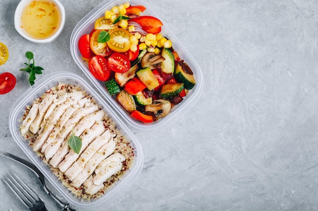 Meal prep lunch box containers with quinoa grilled and fresh vegetables and chicken