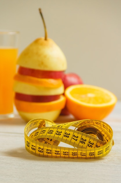 Photo measure tape and fresh fruit on wooden table. healthy lifestyle diet with fresh fruits.