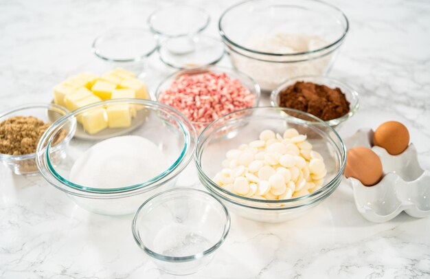 Measured ingredients in a glass mixing bowl to prepare peppermint white chocolate cookies