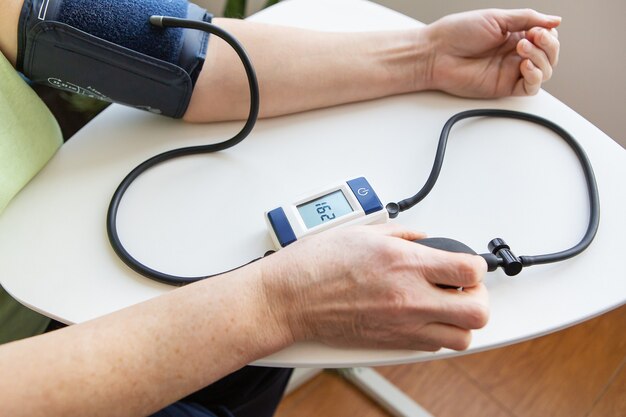 Measurement of blood pressure. The woman measures blood pressure. Self-diagnosis at home.