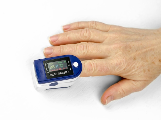 Measurement of saturation in a 60-year-old woman Health care for the elderly Pulse oximeter on the finger of an elderly woman