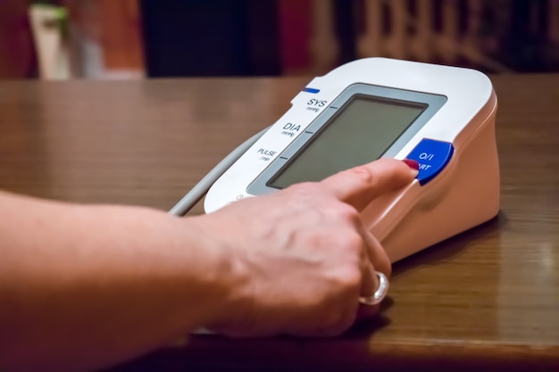 measuring blood pressure and female finger presses the start button