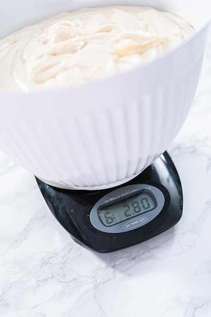 Measuring cake batter by weight on a digital kitchen scale.