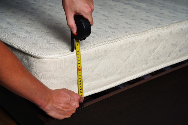 Measuring the height of the mattress with a measuring tape comfortable sleep orthopedic bed