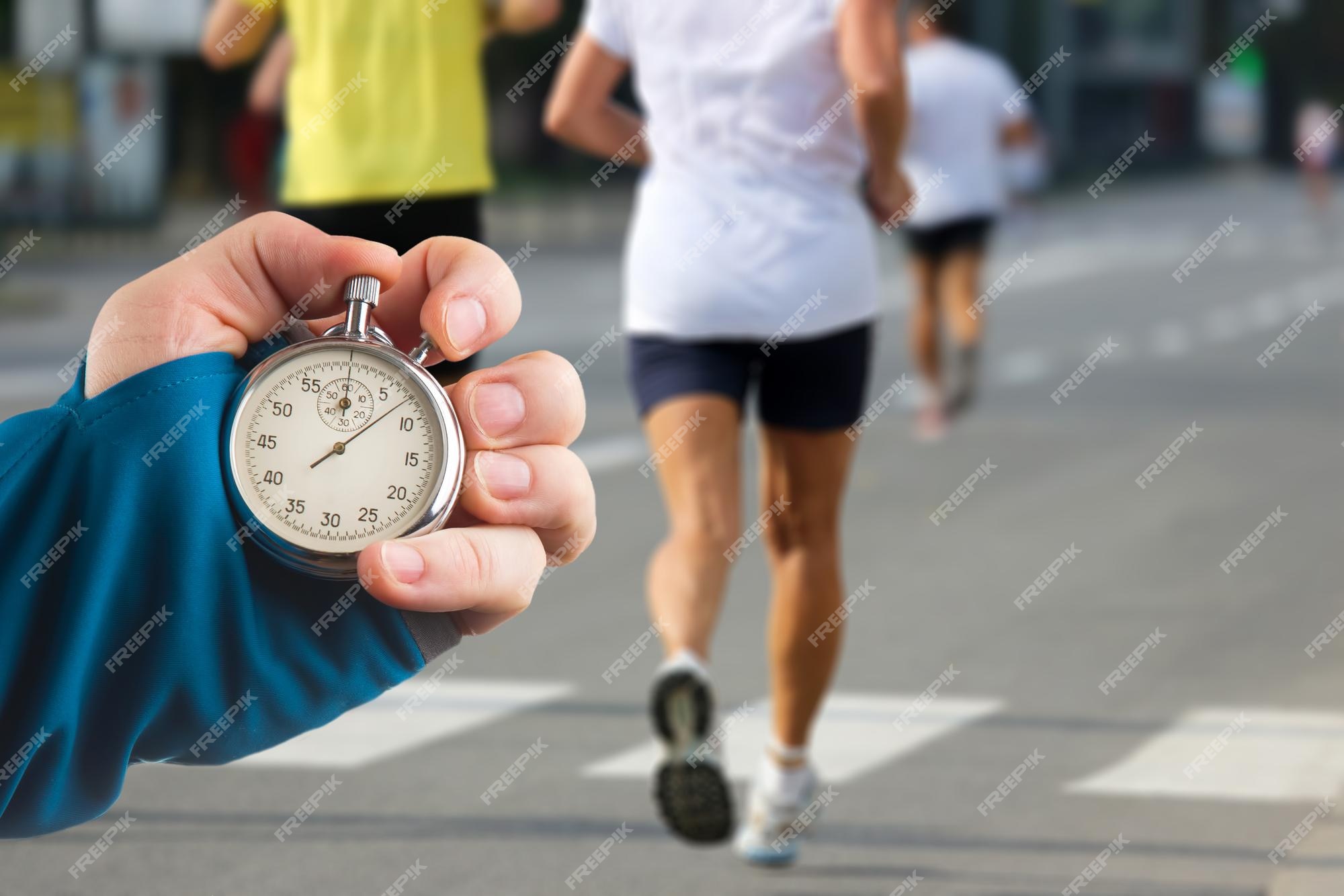 Premium Photo  Measuring the running speed of an athlete using a  mechanical stopwatch. hand with a stopwatch on the background of the legs  of a runner.