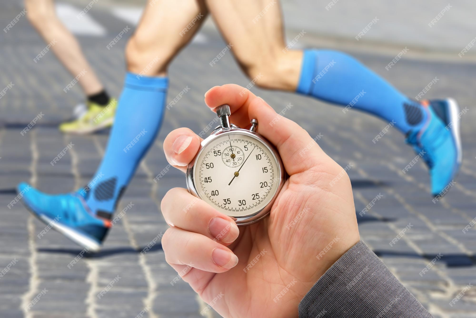 Measuring the Running Speed of an Athlete Using a Mechanical Stopwatch.  Hand with a Stopwatch on the Background of the Legs of a Stock Image -  Image of chronometer, monitor: 257808953