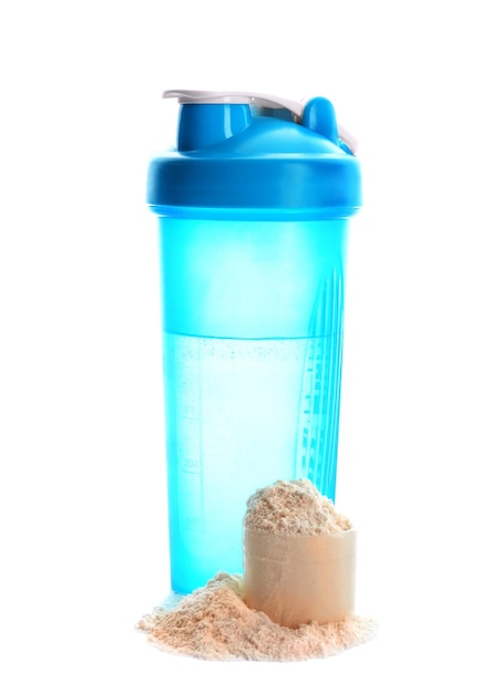 Measuring scoop with protein powder and bottle of water on white background