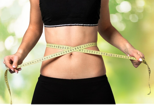 measuring tape around slim beautiful waist.
