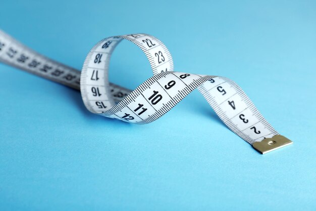 Measuring tape on blue background