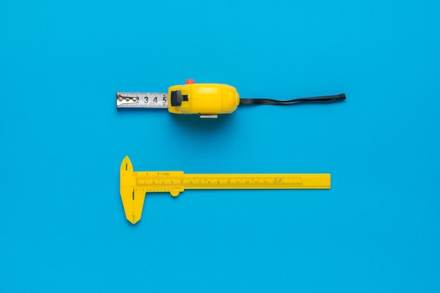 Measuring tape and caliper on a blue background Minimal concept of measuring instruments