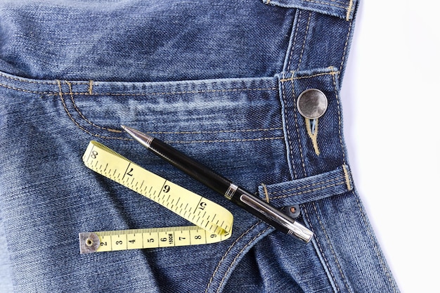 Measuring tape on front blue jeans