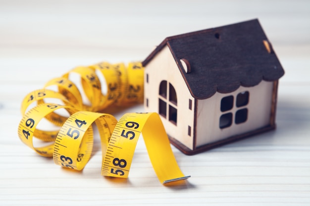 Measuring tape and house on the table