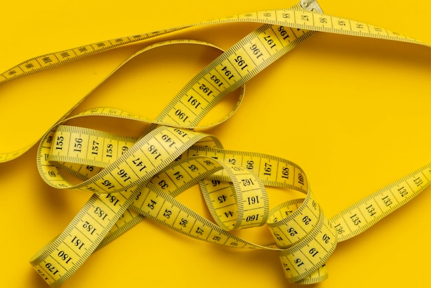 measuring tape isolated on yellow background isolated b