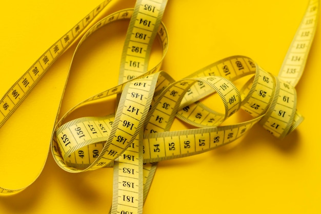 measuring tape isolated on yellow background isolated b