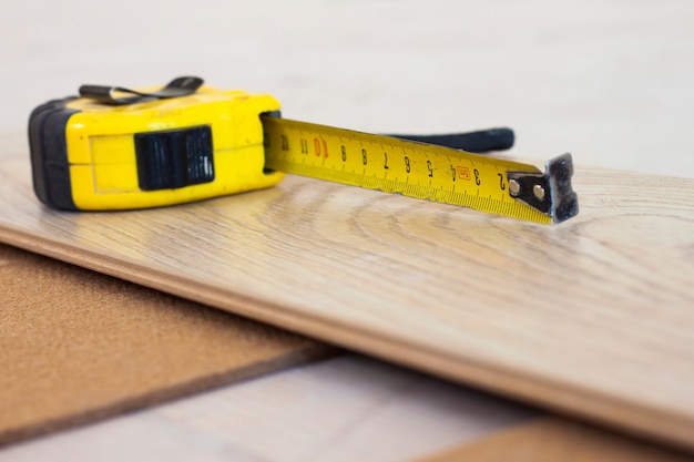 Measuring tape on laminate floor plank