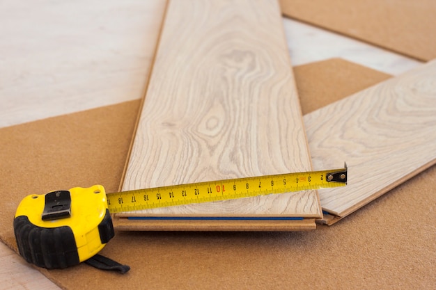 Measuring tape on laminate floor plank