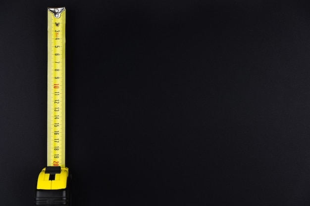 Measuring tape measure in yellow on a black background