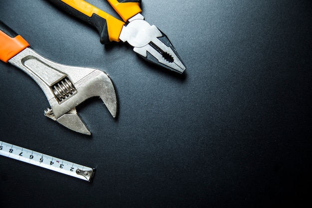 Measuring tape, pliers and adjustable wrench with yellow handles