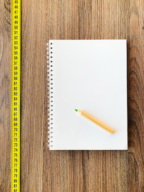 Nastro di misurazione con blocco note e penna del diario del libro per forma fisica sana