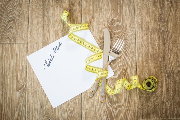 Measuring tape on a wooden background. diet concept