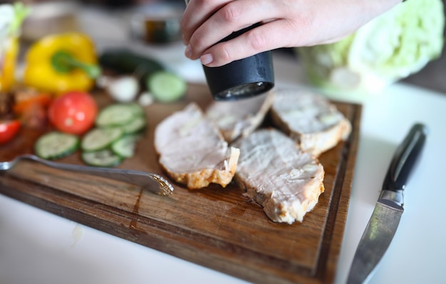 Photo meat bacon pork or veal cooked by chef hands on wooden board adding spices cooking meat concept