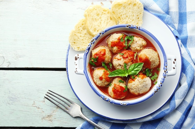 Meat balls with tomato sauce on wooden background