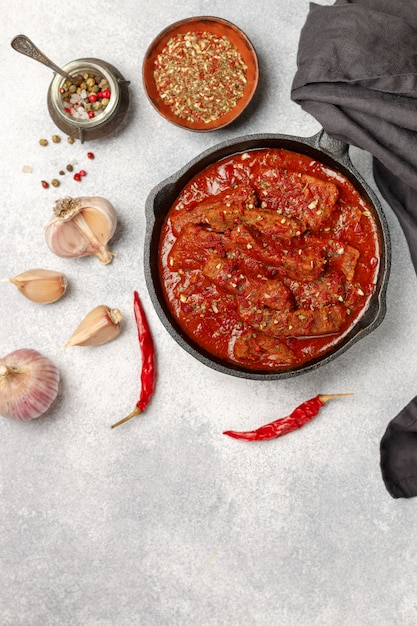 Foto carne (manzo) in umido in salsa di pomodoro con aglio e spezie. gulasch