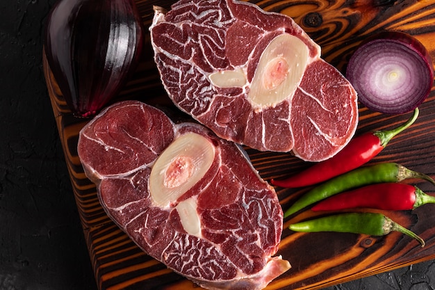 Meat beef veal shank sliced meat on dark  wooden cutting board.