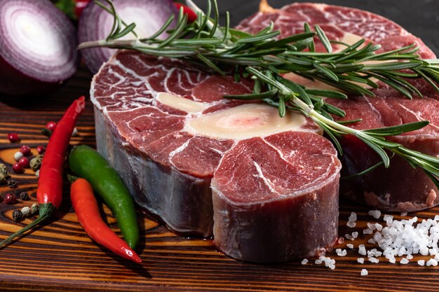 Meat beef veal shank sliced meat on dark  wooden cutting board.