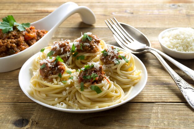 Meat Bolognese sauce with spaghetti on a wooden table