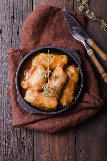 Meat in cabbage rolls in a black pan with sauce