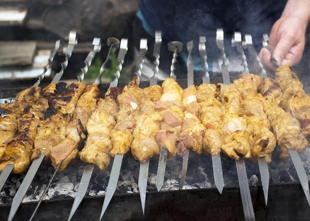 Мясо готовится на раскаленных углях в дыму Пикник на природе Свинина жарится на гриле