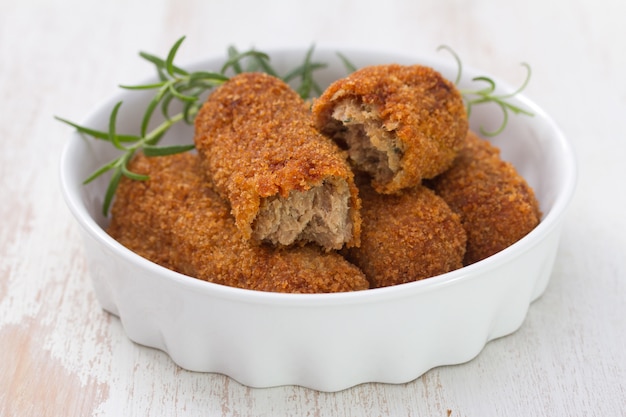 Meat croquettes in dish on white