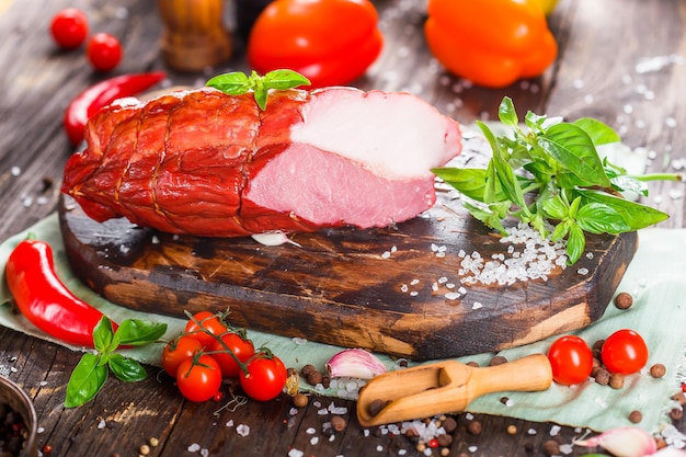 Meat delicacy, boiled pork beautiful, whole or sliced on a kitchen cutting board dark and moody