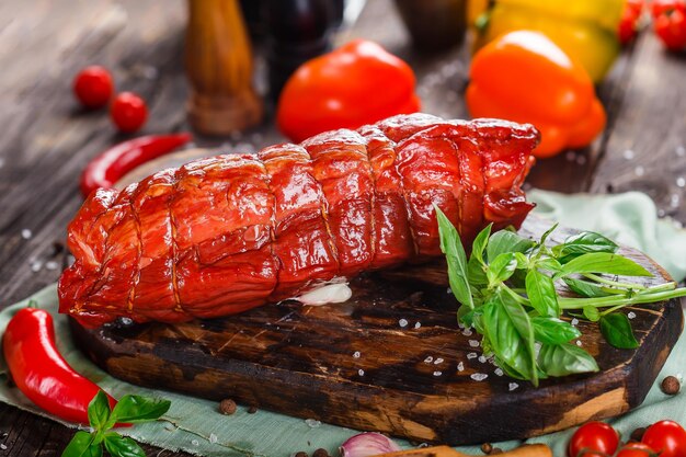 Foto prelibatezza di carne, bello il bollito di maiale, intero o affettato su un tagliere da cucina, spezie