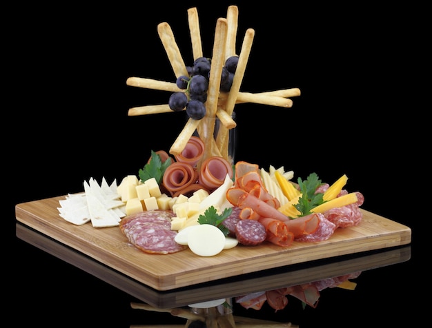 Meat delicatessen plate with cheese and grissini