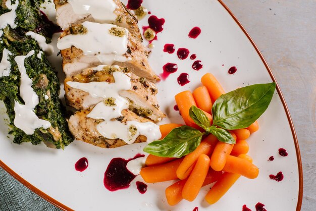 Foto piatto di carne con salsa e carote sullo sfondo di legno